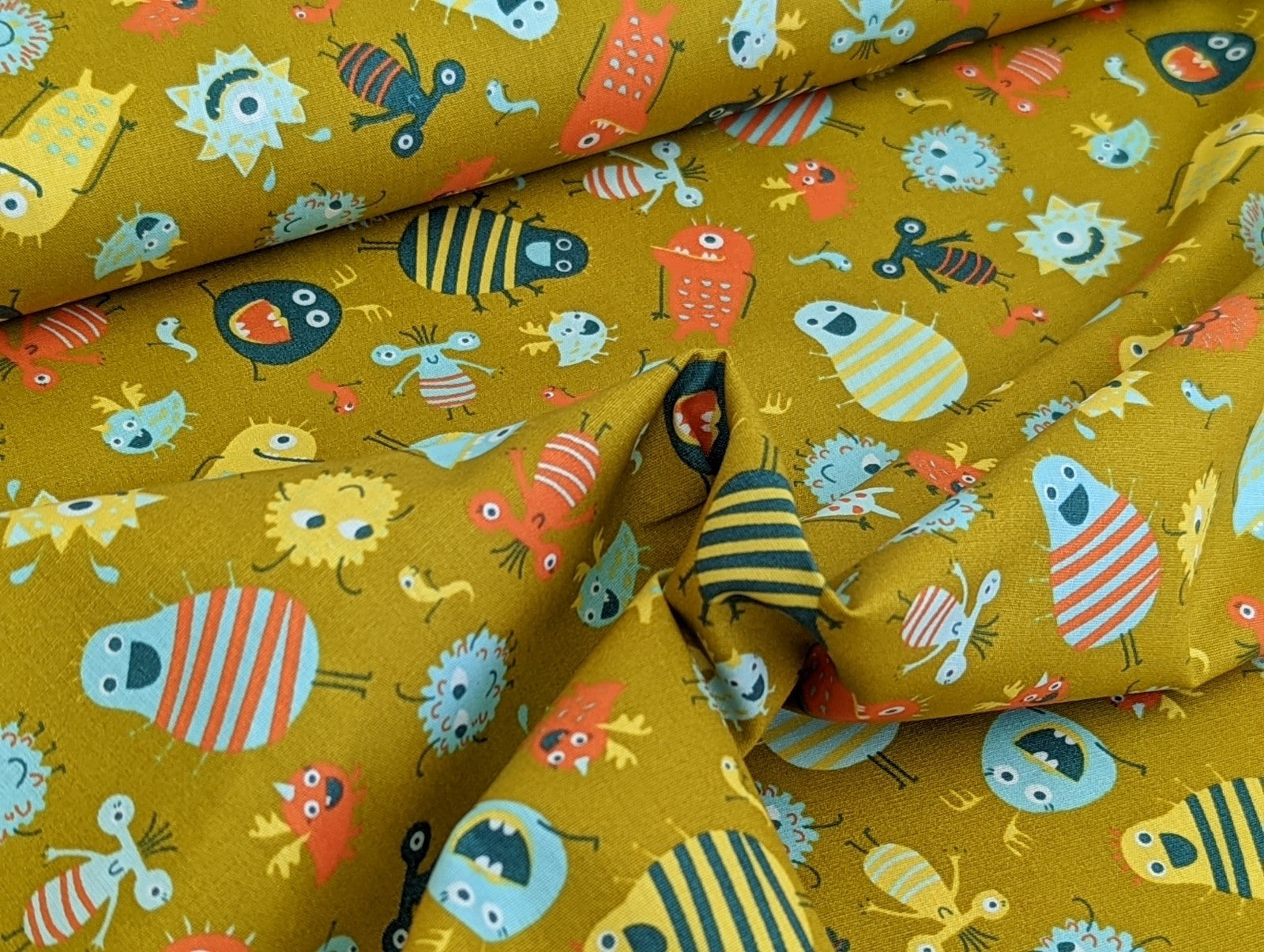 Baumwollstoff Poplin Kleine Aliens Monster auf Senf Gelb